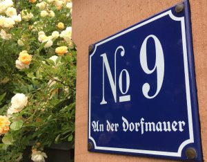Foto vom nostalgischen Hausnummernschild "An der Dorfmauer 9" in Großostheim OT Pflaumheim mit Rose Ghislaine de feligonde